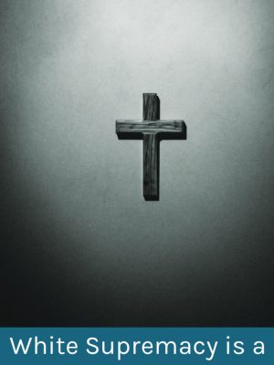 Black and white image of a wooden cross on a wall. Text overlay reads: "White Supremacy is a False God"